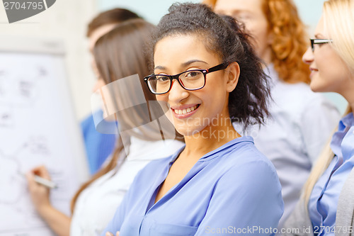 Image of smiling businesswoman with team team on the back