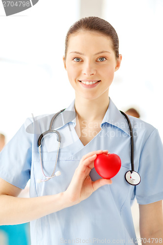 Image of smiling female doctor with heart an stethoscope