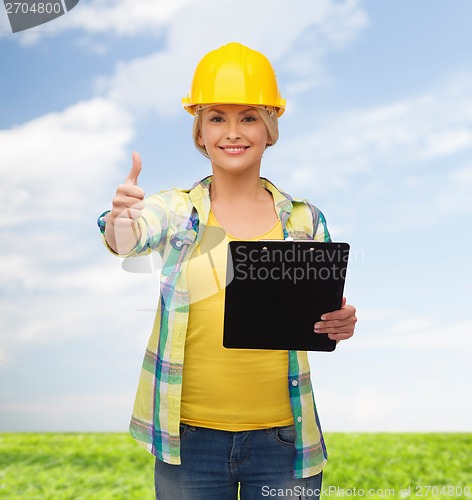 Image of smiling woman in helmet with clipboard