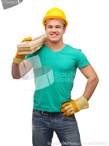 Image of smiling manual worker in helmet with wooden boards