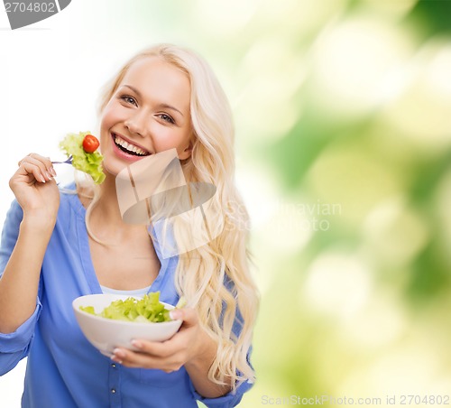 Image of smiling young woman with green salad