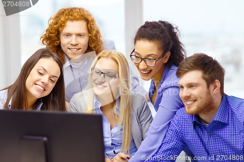 Image of smiling business team looking at computer monitor