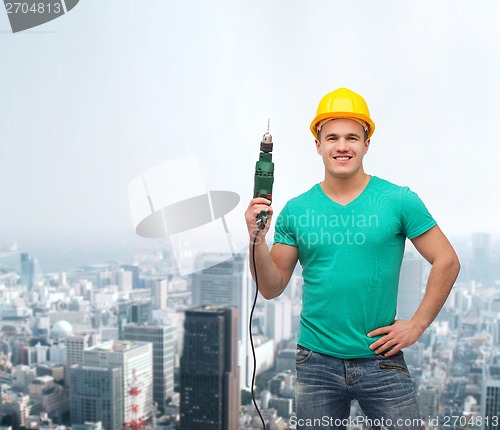 Image of smiling manual worker in helmet with drill machine