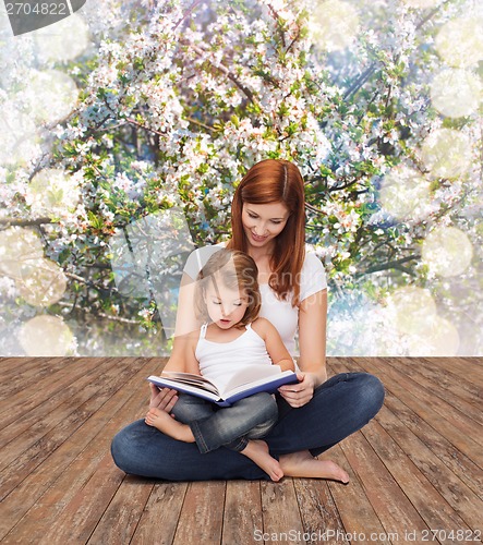 Image of happy mother with adorable little girl and book