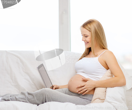 Image of smiling pregnant woman with tablet pc computer
