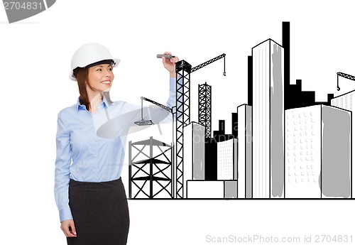 Image of businesswoman in helmet writing on virtual screen