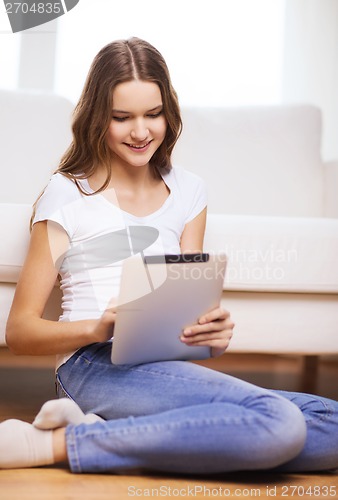 Image of smiling teenage girl with tablet pc at home