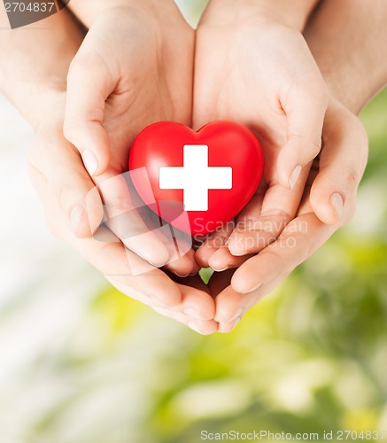 Image of male and female hands with red heart