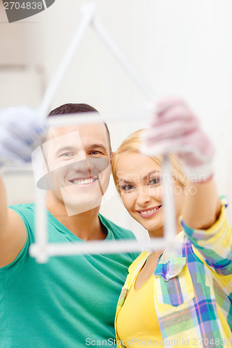 Image of smiling couple with house from measuring tape