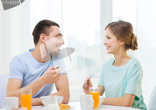 Image of smiling couple having breakfast at home