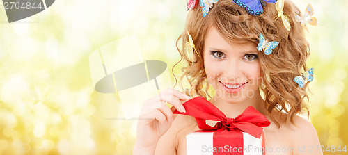 Image of teenager with butterflies in hair opening present