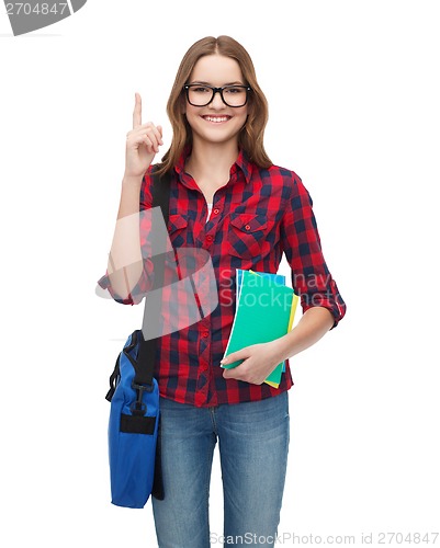 Image of smiling female student with bag and notebooks