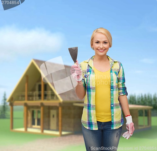 Image of smiling female worker in gloves with spatula