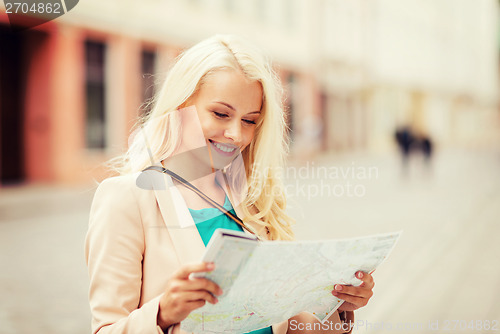 Image of girl looking into tourist map in the city