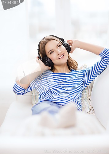 Image of smiling young girl in headphones at home
