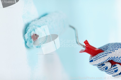 Image of close up of male in gloves painting wall