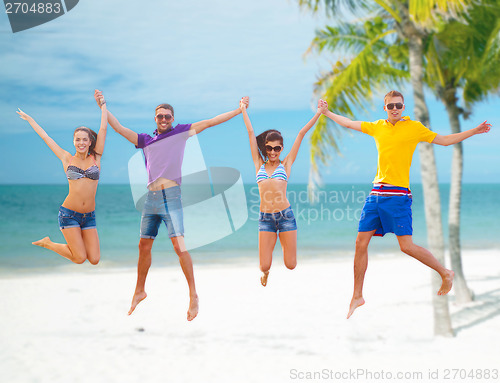 Image of group of friends or couples jumping on the beach