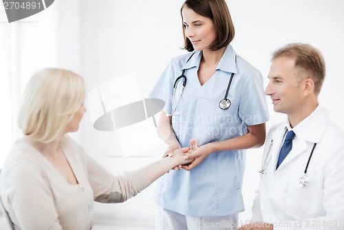 Image of nurse with patient measuring pulse