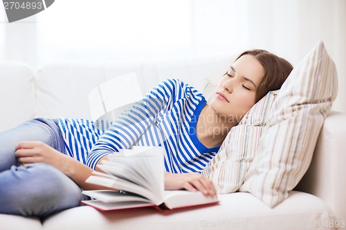 Image of smiling teenage girl sleeping on sofa at home