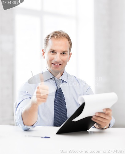 Image of businessman with papers showing thumbs up