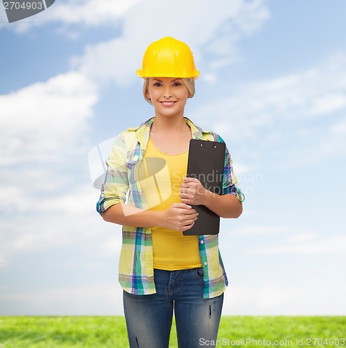 Image of smiling woman in helmet with clipboard