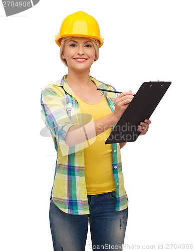 Image of smiling woman in helmet with clipboard