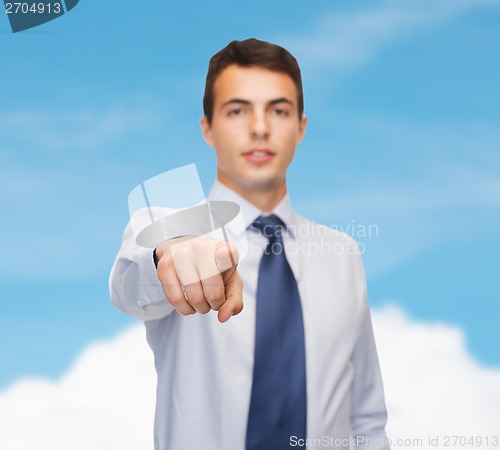 Image of friendly young buisnessman pointing finger