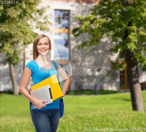 Image of smiling student with bag, folders and tablet pc