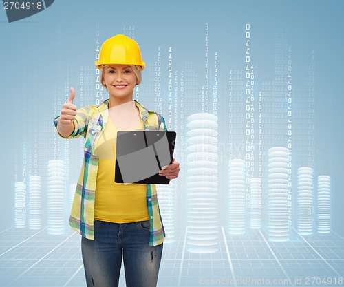 Image of smiling woman in helmet with clipboard