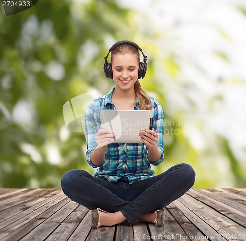 Image of young woman in casual clothes sitting on floor