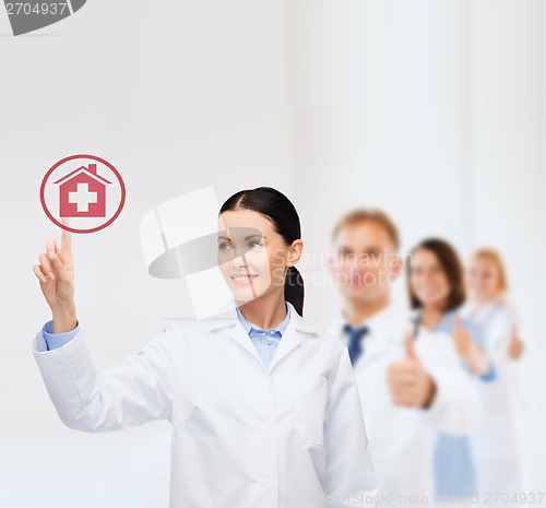 Image of smiling female doctor pointing to hospital sign