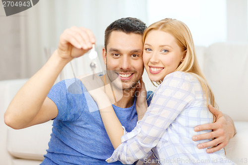 Image of smiling couple holding keys at home