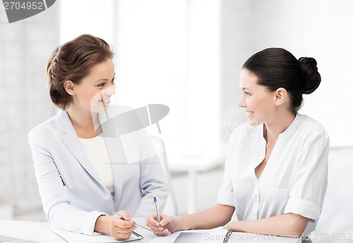 Image of two businesswomen having discussion in office