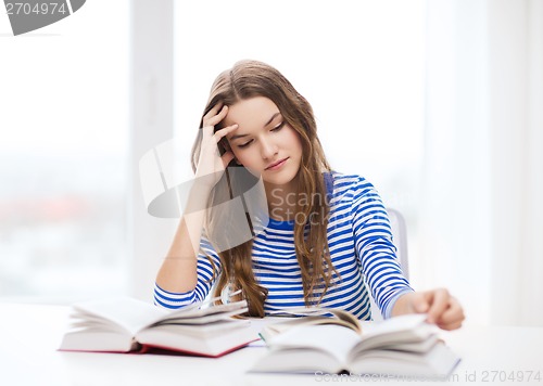 Image of stressed student girl with books