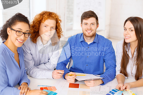 Image of team with color samples and blueprint at office