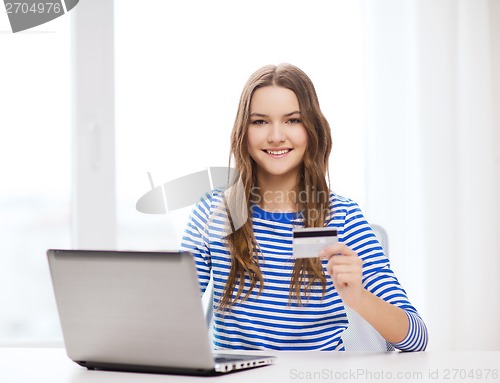 Image of smiling teenage gitl with laptop computer at home