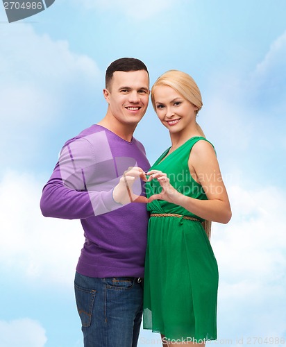 Image of smiling couple showing heart with hands