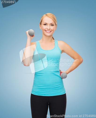 Image of young sporty woman with light dumbbells