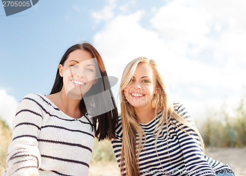 Image of smiling girlfriends having fun on the beach