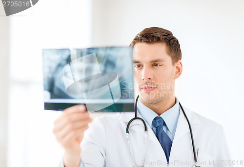 Image of concerned male doctor or dentist looking at x-ray