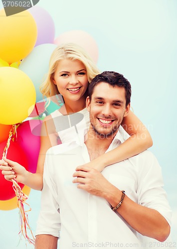 Image of couple with colorful balloons at seaside