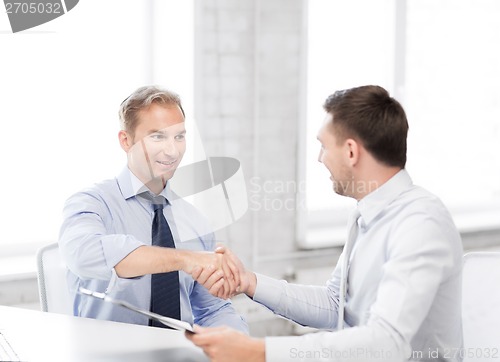 Image of businessmen shaking hands in office