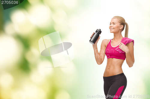 Image of sporty woman drinking water from sportsman bottle