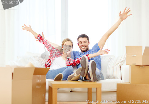 Image of smiling couple relaxing on sofa in new home