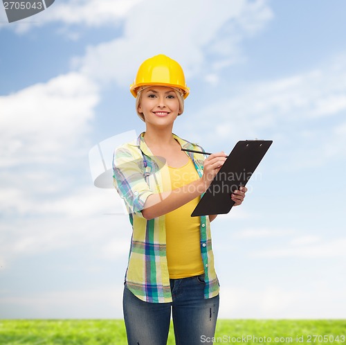 Image of smiling woman in helmet with clipboard