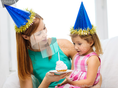 Image of mother and daughter in blue hats with cake