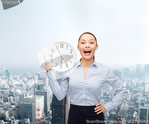 Image of attractive businesswoman with wall clock