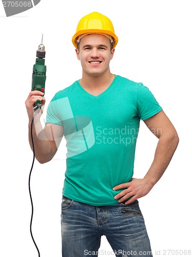 Image of smiling manual worker in helmet with drill machine