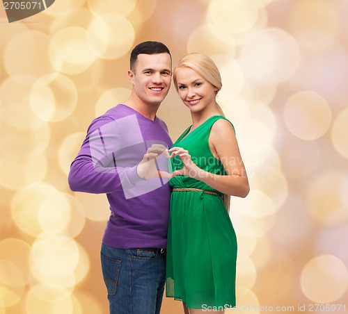 Image of smiling couple showing heart with hands