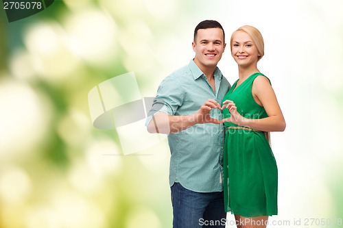 Image of smiling couple showing heart with hands